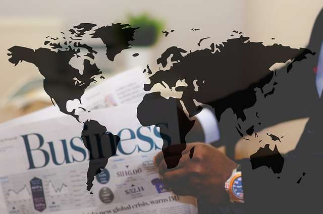 Man holding a krant met de titel 'Business' en wereldkaart overlay, symboliserend wereldwijde zakelijke certificering en ISO-normen.