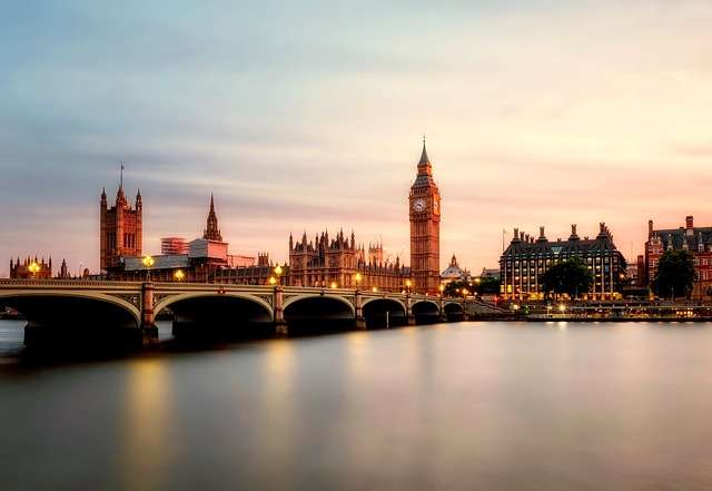 De iconische Big Ben en het Houses of Parliament bij zonsondergang, met de rivier de Theems en de brug op de voorgrond, symboliserend de locatie van Stratlane's ISO-certificeringsdiensten in Londen.
