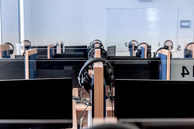 Lege computerwerkplekken met hoofdtelefoons in een onderwijsomgeving, illustrerend de focus op kwaliteitsbeheer en ISO-certificering voor onderwijsinstellingen.